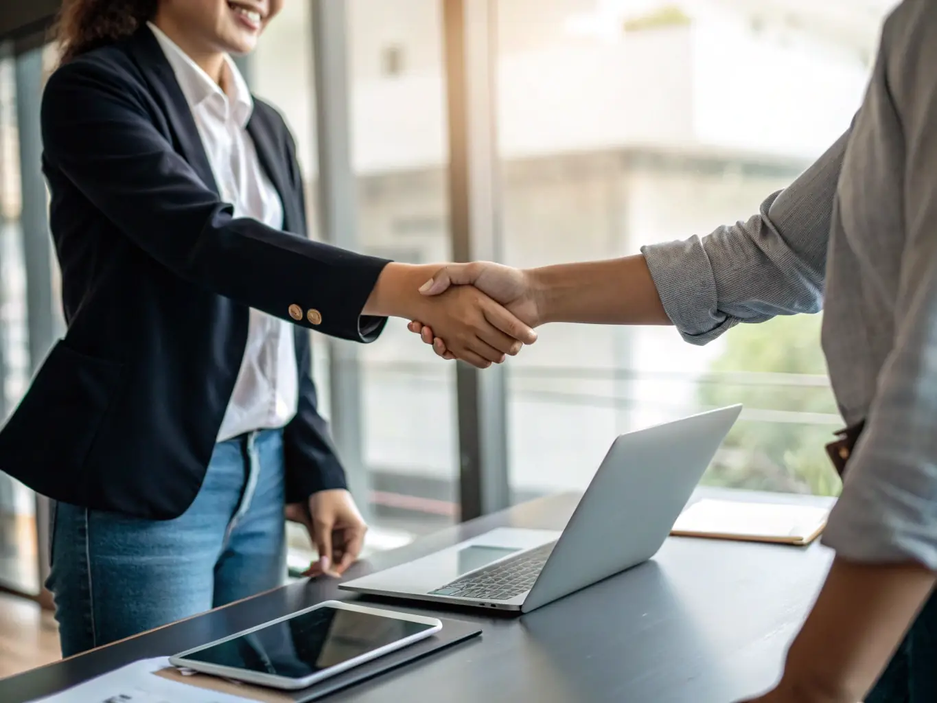 An image depicting a financial advisor shaking hands with a client in front of the Mexican flag, symbolizing trust and partnership.